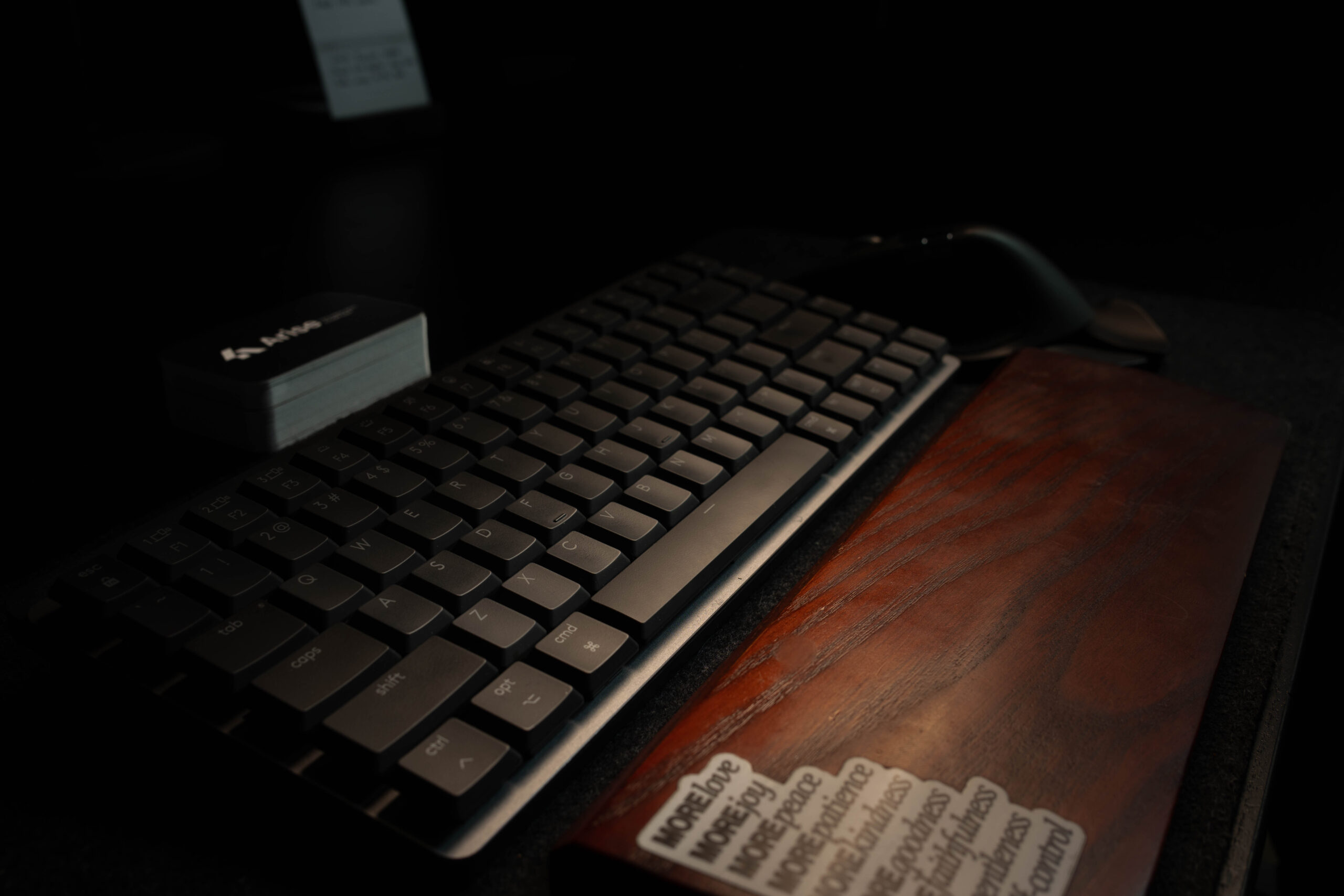 Keyboard and wood wrist rest at the Arise workspace.